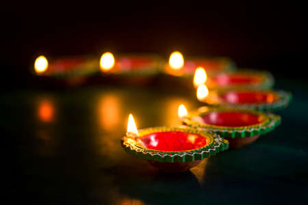 Happy Diwali - Clay Diya lamps lit during Diwali celebration. Greetings Card Design of Indian Hindu Light Festival called Diwaliの写真素材