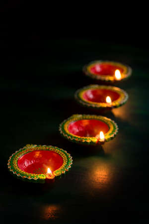 Happy Diwali - Clay Diya lamps lit during Diwali celebration. Greetings Card Design of Indian Hindu Light Festival called Diwaliの写真素材