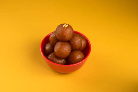 Indian Dessert or Sweet Dish : Gulab Jamun in bowl on yellow background.の写真素材