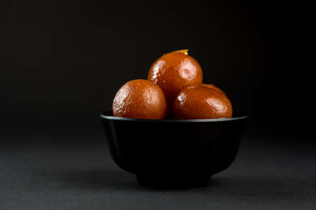 Gulab Jamun in bowl on black background. Indian Dessert or Sweet Dish.の写真素材