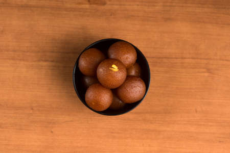 Indian Dessert or Sweet Dish : Gulab Jamun in bowl on wooden background.の写真素材