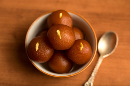 Gulab Jamun in bowl on wooden background. Indian Dessert or Sweet Dish.の写真素材