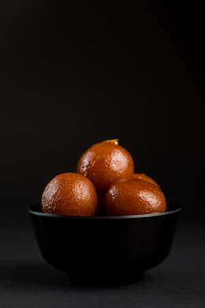 Gulab Jamun in bowl on black background. Indian Dessert or Sweet Dish.の写真素材
