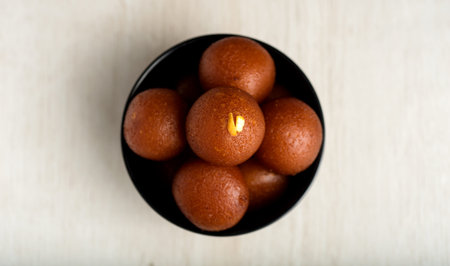 Indian Dessert or Sweet Dish : Gulab Jamun in bowl on wooden background.の写真素材