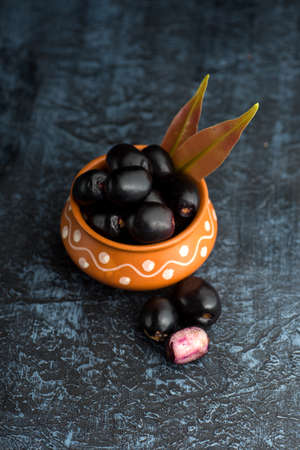 Jambolan plum or jambul or Jamun fruit, Java plum (Syzygium cumini) with leaf on stone textured background.の写真素材