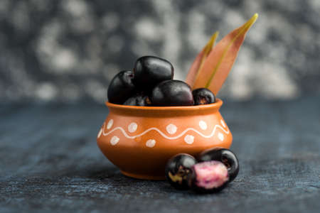 Jambolan plum or jambul or Jamun fruit, Java plum (Syzygium cumini) with leaf on stone textured background.の写真素材