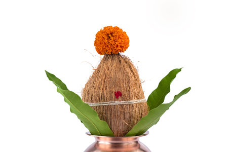 Copper Kalash with coconut and mango leaf with floral decoration on a white background. Essential in...
