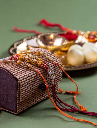 Indian Festival: Raksha Bandhan or Rakhi background with an elegant Rakhi and diyaの写真素材