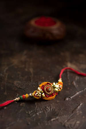 Raksha Bandhan background with an elegant Rakhi, Rice Grains and Kumkum. A traditional Indian wrist band which is a symbol of love between Brothers and Sisters.の写真素材