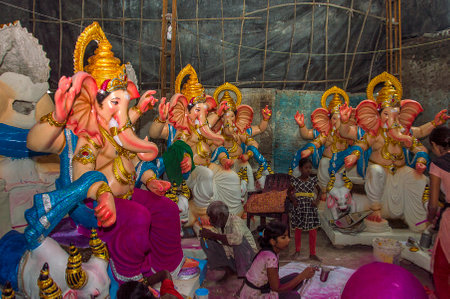AMRAVATI, MAHARASHTRA - SEPTEMBER 8, 2018: Artist making a statue and gives finishing touches on an idol of the Hindu god Lord Ganesha at an artist's workshop for Ganesha festival.のeditorial素材