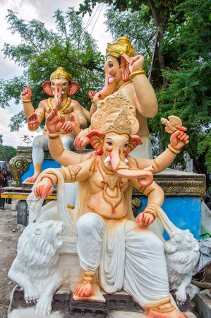 AMRAVATI, MAHARASHTRA - SEPTEMBER 8, 2018: Artist making a statue and gives finishing touches on an idol of the Hindu god Lord Ganesha at an artist's workshop for Ganesha festival.のeditorial素材