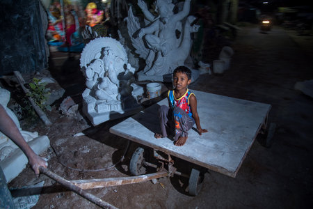 AMRAVATI, MAHARASHTRA - SEPTEMBER 8, 2018: Artist making a statue and gives finishing touches on an idol of the Hindu god Lord Ganesha at an artist's workshop for Ganesha festival.のeditorial素材