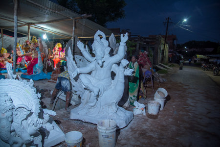 AMRAVATI, MAHARASHTRA - SEPTEMBER 8, 2018: Artist making a statue and gives finishing touches on an idol of the Hindu god Lord Ganesha at an artist's workshop for Ganesha festival.のeditorial素材