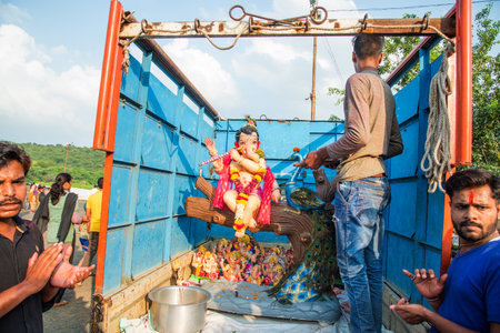 AMRAVATI, MAHARASHTRA, INDIA - 23 SEPTEMBER 2018: Unidentified faithful people perform pray of Hindu God Ganesha before immersion near water bodies during Ganesh festival. Ganesh Chaturthi is an annuaのeditorial素材