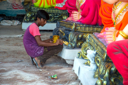 AMRAVATI, MAHARASHTRA - SEPTEMBER 8, 2018: Artist making a statue and gives finishing touches on an idol of the Hindu god Lord Ganesha at an artist's workshop for Ganesha festival.のeditorial素材