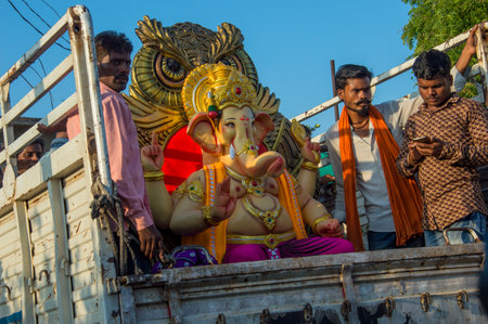 AMRAVATI, MAHARASHTRA - SEPTEMBER 8, 2018: Artist making a statue and gives finishing touches on an idol of the Hindu god Lord Ganesha at an artist's workshop for Ganesha festival.のeditorial素材