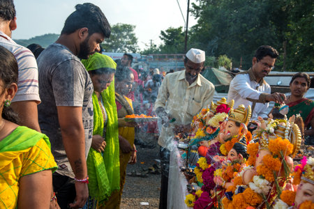 AMRAVATI, MAHARASHTRA, INDIA - 23 SEPTEMBER 2018: Unidentified faithful people perform pray of Hindu God Ganesha before immersion near water bodies during Ganesh festival. Ganesh Chaturthi is an annuaのeditorial素材