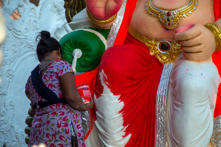 AMRAVATI, MAHARASHTRA - SEPTEMBER 8, 2018: Artist making a statue and gives finishing touches on an idol of the Hindu god Lord Ganesha at an artist's workshop for Ganesha festival.のeditorial素材