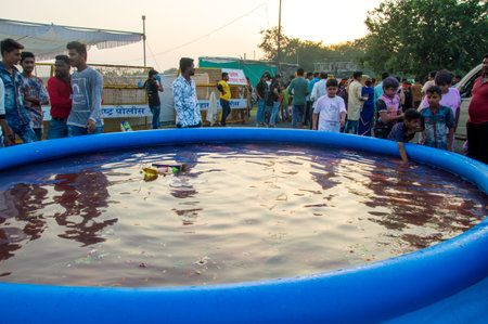 AMRAVATI, MAHARASHTRA, INDIA - 23 SEPTEMBER 2018: Unidentified devotees immersing the idol of Hindu god Ganesha in waters of an artificial pond on last day of festival Ganesha Chaturthi festival.のeditorial素材