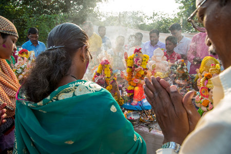 AMRAVATI, MAHARASHTRA, INDIA - 23 SEPTEMBER 2018: Unidentified faithful people perform pray of Hindu God Ganesha before immersion near water bodies during Ganesh festival. Ganesh Chaturthi is an annuaのeditorial素材