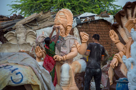 AMRAVATI, MAHARASHTRA - SEPTEMBER 8, 2018: Artist making a statue and gives finishing touches on an idol of the Hindu god Lord Ganesha at an artist's workshop for Ganesha festival.のeditorial素材