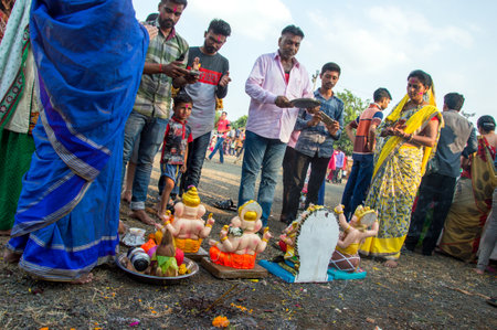 AMRAVATI, MAHARASHTRA, INDIA - 23 SEPTEMBER 2018: Unidentified faithful people perform pray of Hindu God Ganesha before immersion near water bodies during Ganesh festival. Ganesh Chaturthi is an annuaのeditorial素材