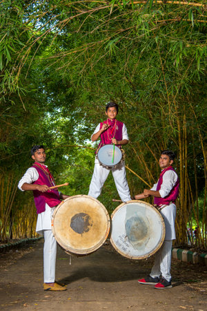 AMRAVATI, MAHARASHTRA, INDIA - SEPTEMBER 24: Unidentified group of young people celebrating Festival in park by playing drums with music.のeditorial素材