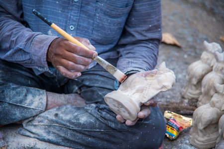 AMRAVATI, MAHARASHTRA - AUGUST 24, 2018: Artist gives finishing touches on statue of Bull at an...