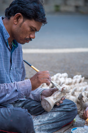 AMRAVATI, MAHARASHTRA - AUGUST 24, 2018: Artist gives finishing touches on statue of Bull at an artist's workshop for Bail (Bull) Pola Festival.のeditorial素材