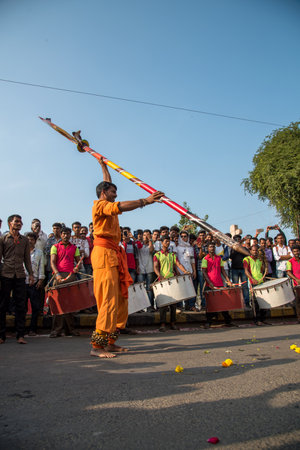 AMRAVATI, MAHARASHTRA, INDIA - 27 SEPTEMBER 2018: A man performing with heavy Trishul (Trident) in front of a crowd of people with beating traditional drums during Ganesh immersion. Ganesha Chaturthi.のeditorial素材