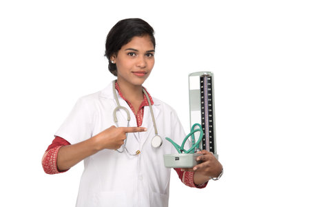 Portrait of a woman doctor with blood pressure instrument and stethoscope on white background.