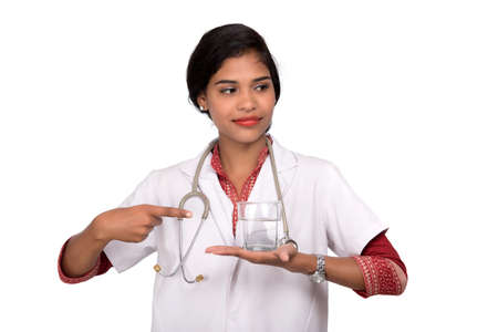 Healthy eating or lifestyle concept: Smiling female doctor holding a glass of clear fresh waterの写真素材