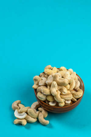 Cashew nuts in a bowl on blue backgroundの写真素材