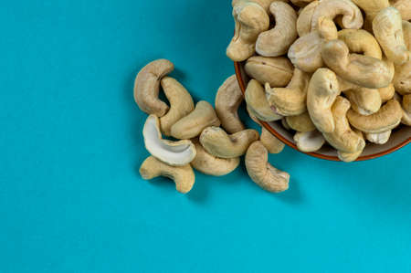 Cashew nuts in a bowl on blue backgroundの写真素材