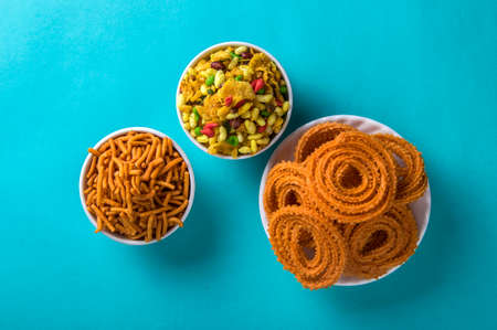 Indian Snack : Chakli, chakali or Murukku and Besan (Gram flour) Sev and chivada or chiwada on blue background. Diwali Foodの写真素材