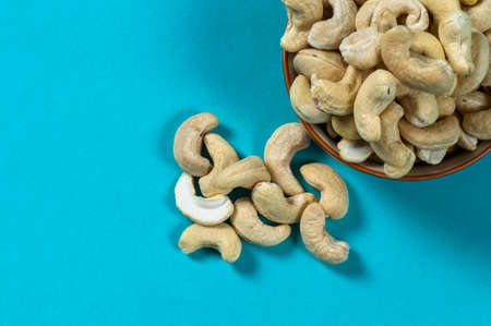Cashew nuts in a bowl on blue backgroundの写真素材