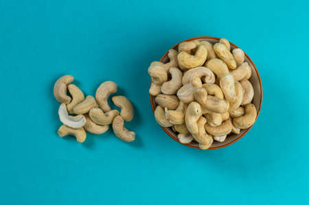 Cashew nuts in a bowl on blue backgroundの写真素材