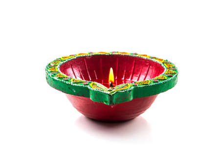 Single Clay diya lamp lit during diwali festival. Happy Diwali Greetings Card Design, Indian Hindu Festival of Lights called Diwali.