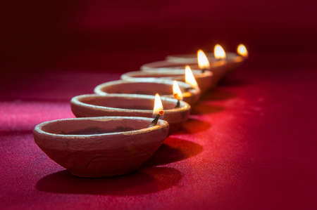 Clay diya lamps lit during Diwali Celebration. Greetings Card Design Indian Hindu Light Festival called Diwaliの写真素材