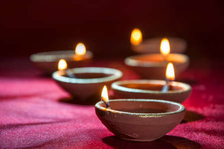 Clay diya lamps lit during Diwali Celebration. Greetings Card Design Indian Hindu Light Festival called Diwaliの写真素材