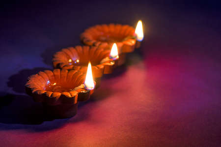 Clay diya lamps lit during Diwali Celebration. Greetings Card Design Indian Hindu Light Festival called Diwaliの写真素材