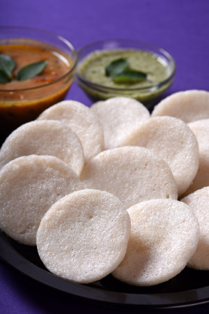 Idli with Sambar and coconut chutney on violet background, Indian Dish : south Indian favourite food...