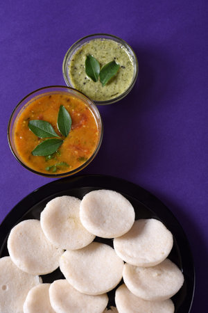 Idli with Sambar and coconut chutney on violet background, Indian Dish : south Indian favourite food...
