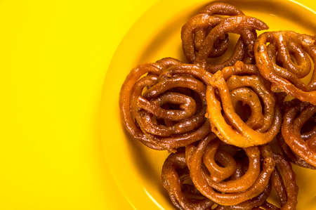 Indian sweet jalebi, indian dessert jalebi or imarti or imarati or jilbi on yellow backgroundの素材 [FY310136030084]