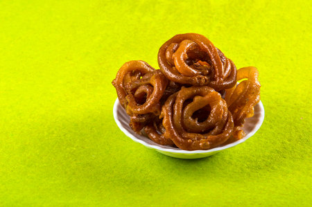 Jalebi Indian sweet dish on green background