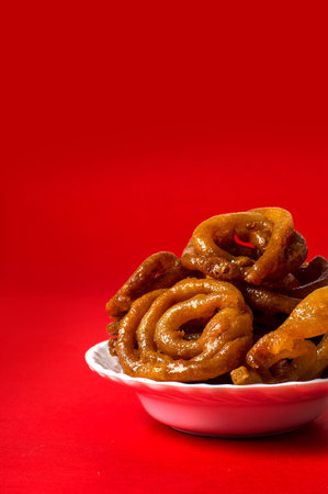 Indian sweet jalebi, indian dessert jalebi or imarti or imarati or jilbi on red background