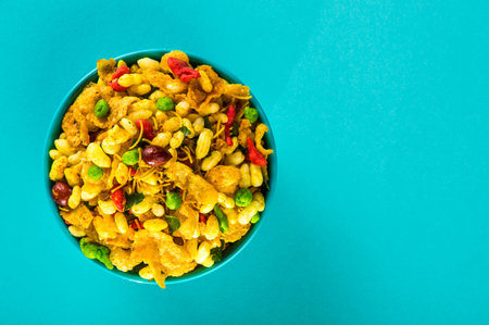 Indian Snacks: Traditional Indian deep fried salty dish called chivda or mixture or farsan made of gram flour and mixed with dry fruits and roasted nuts with salt, pepper, pulses, spice and green peasの写真素材