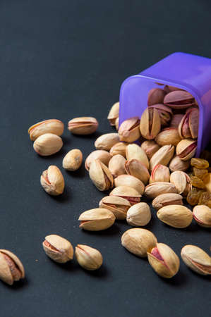 Healthy Mix Dry Fruits and Nuts on dark background. Almonds, Pistachio, Cashews, Raisinsの写真素材