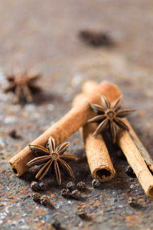 Cinnamon sticks, anise stars and black peppercorns on textured backgroundの写真素材