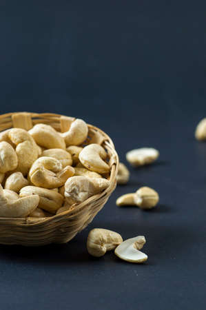 Cashew nuts in basket on black backgroundの写真素材